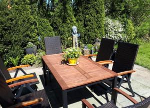 a wooden table with chairs and a vase of flowers on it at Maritim in Steffenshagen