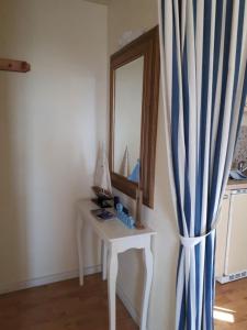 a dressing table with a mirror and a curtain at Maritim in Steffenshagen