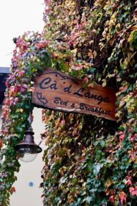 a sign on the side of a building covered in flowers at Cà 'd Langa B&B in Treiso