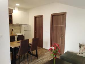 a kitchen and dining room with a table and chairs at Pocanic apartmani in Tivat