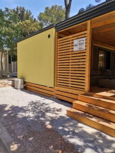 una casa con un exterior de madera y amarillo en Mobile Home Mali raj, en Biograd na Moru
