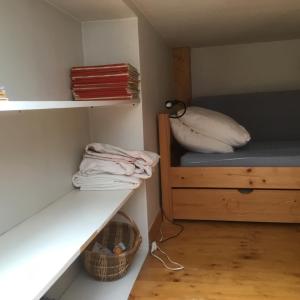 ein kleines Zimmer mit einem Bett und einem Regal in der Unterkunft Appartement typique,chaleureux et pratique in Chamonix-Mont-Blanc