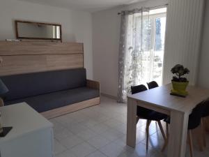 sala de estar con cama, mesa y sillas en Studio en plein centre ville - 2 à 4 personnes, en Tence