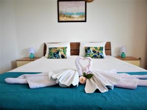 - un lit avec des serviettes et un bow dans l'établissement Vila Teodora, à Sveti Stefan