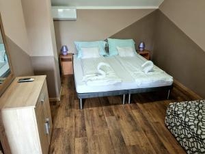 a bedroom with a bed with towels on it at Csalogány-Lak in Tiszavasvári