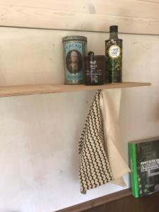 a shelf with two bottles of alcohol and a towel at Leopold der Lamahütewagen in Oberndorf an der Melk