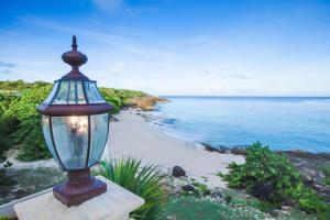 una luz de la calle junto a una playa con el océano en Sandcastle Villa en Crocus Hill