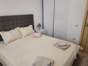 a bedroom with a large bed with two towels on it at Mona in Mamaia