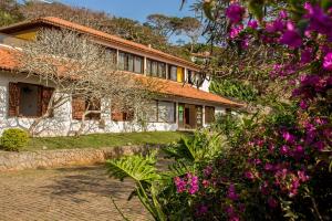 a house with pink flowers in front of it at The Eco Palace Hostel in Búzios