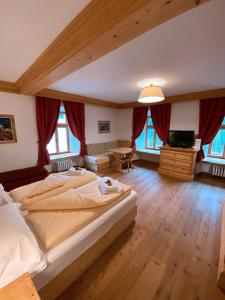 - une grande chambre avec 2 lits et une télévision dans l'établissement Ristorante Rifugio Ospitale, à Cortina dʼAmpezzo