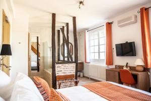 um quarto com uma cama, uma secretária e uma televisão em Le Moulin d'Hauterive em Saint-Gervais-en-Vallière