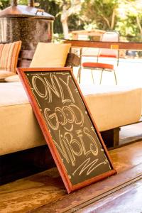 a chalkboard sign on the floor next to a bed at The Eco Palace Hostel in Búzios
