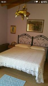 a bedroom with a large white bed with a chandelier at Sherdana's in Padru