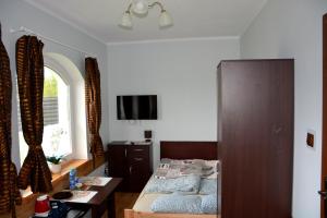 a bedroom with a bed and a table and a window at Apartamenty i Pokoje Gościnne Ala in Szklarska Poręba