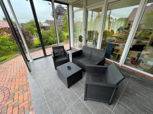 an empty patio with chairs and a table in a building at Ferienhaus Kompass (ehemals Pension Hohlen) in Carolinensiel
