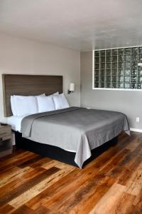 - une chambre avec un grand lit et du parquet dans l'établissement Lockhart Inn, à Lockhart