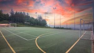 una pista de tenis vacía con una puesta de sol en el fondo en Villa Giuliana B&B, en Scarperia