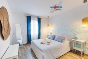 sypialnia z białym łóżkiem i lustrem w obiekcie Vivienda Vacacional Buganvillas w Costa Teguise +32 zdjęcia