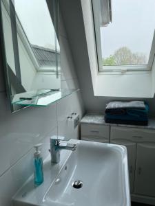 a white bathroom with a sink and a mirror at Meyers Ausguck in Zingst