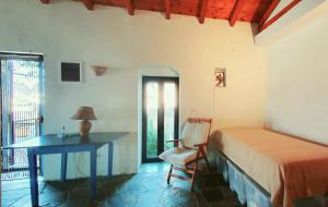 a bedroom with a bed and a desk and a chair at Traditional Hillside Cottage in Gythio +4 photos