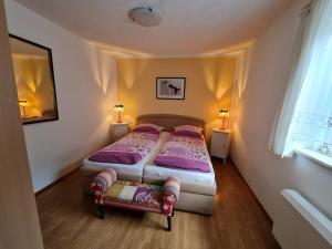 2 camas en una habitación pequeña con 2 lámparas en Camping Gasthof Zirknitzer, en Großkirchheim