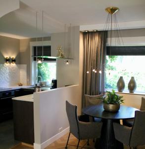 een keuken en een woonkamer met een tafel, een keuken en een aanrecht bij Hoeve Altena Apartment in Woudrichem