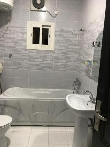 y baño con bañera y lavamanos. en كريستال الذهبية en Taif