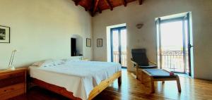 a bedroom with a bed and a chair and a window at Traditional Hillside Cottage in Gythio