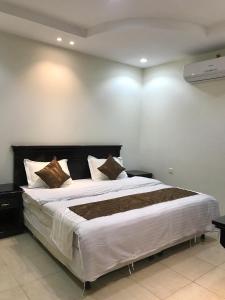 um quarto com uma cama grande num quarto em كريستال الذهبية em Taif
