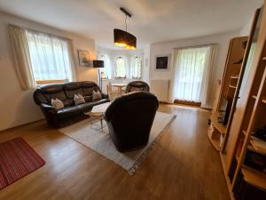 a living room with a leather couch and a table at Camping Gasthof Zirknitzer in Großkirchheim