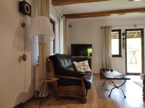 uma sala de estar com uma cadeira de couro e uma televisão em Dom na skraju lasu em Serwy
