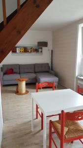 a living room with a white table and a couch at Petite maison mignonette in Pléneuf-Val-André