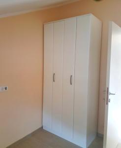 Zimmer mit weißen Schränken und einer Wand in der Unterkunft Apartmani Popović V&A in Tivat