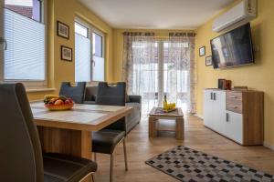 a living room with a table and chairs and a kitchen at Im Unterdorf Apartments Rust in Rust