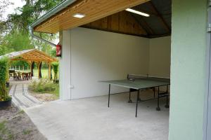 a ping pong table on the side of a patio at Agroturystyka PLENER in Miedzichowo