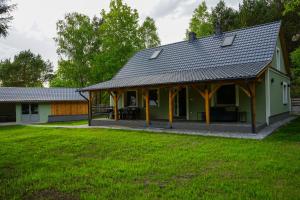 Agroturystyka PLENER في Miedzichowo: منزل اخضر بسقف مقامر
