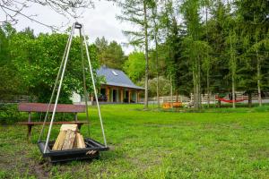 a swing in a yard in front of a house at Agroturystyka PLENER in Miedzichowo