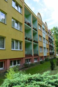 an apartment building with balconies and plants at Hotel Olimp in Chojnice