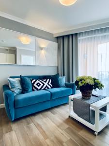 a living room with a blue couch and a table at SeaHome Horyzont z parkingiem in Międzyzdroje