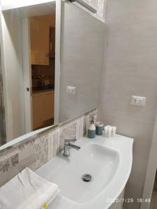 a white bathroom sink with a large mirror at Casa Vacanze Dany in Taranto