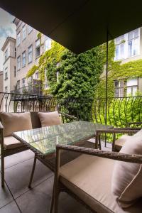 einen Tisch und Stühle auf einem Balkon mit Sonnenschirm in der Unterkunft Premium Residence near Parlament in @YourVienna in Wien