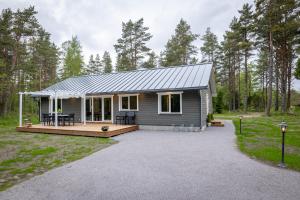 ein kleines Haus mit einer Veranda und einer Terrasse in der Unterkunft Jõeranna Lodge in Paope