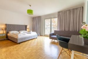 sypialnia z łóżkiem, kanapą i stołem w obiekcie Naschmarkt Premium Apartment in "Your Vienna" w Wiedniu