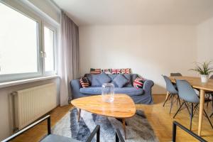 salon z niebieską kanapą i stołem w obiekcie Naschmarkt Premium Apartment in "Your Vienna" w Wiedniu +16 zdjęć