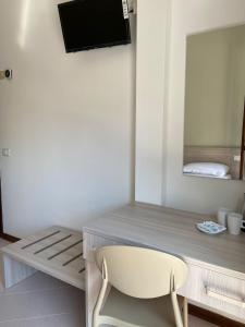 krzesło siedzące przed biurkiem z telewizorem w obiekcie Hotel Ammare w mieście Sottomarina