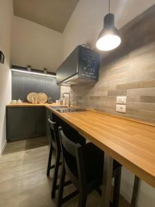 una cucina con bancone in legno e un bar con sedie di StArt GuestHouse a Barletta