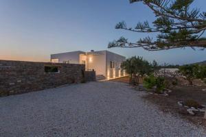 a home with a stone wall and a building at VILLA GEM POUNTA in Pounda