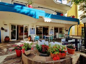 un patio con plantas, mesas y sillas en Hotel Adria B&B - Colazione fino alle 12, en Misano Adriatico
