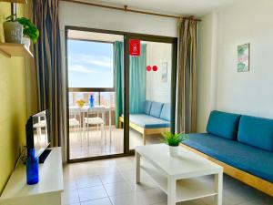 ein Wohnzimmer mit einem blauen Sofa und einem Tisch in der Unterkunft Apartamentos Paraiso 10 by Gestaltur in Benidorm