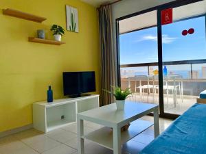 a living room with a tv and a couch and a table at Apartamentos Paraiso 10 by Gestaltur in Benidorm